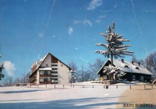 Peisaj de iarnă cu cabane înzăpezite