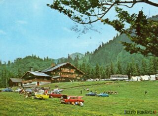 Peisaj montan cu pensiune și mașini retro