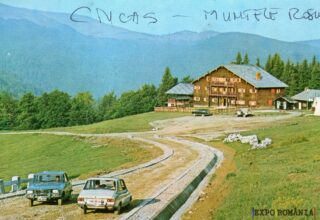 Peisaj montan cu pensiune și mașini retro