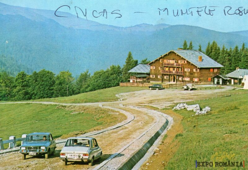 Peisaj montan cu pensiune și mașini retro