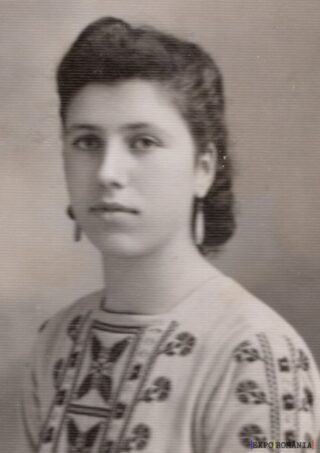 Portret alb-negru al unei tinere în cămașă tradițională