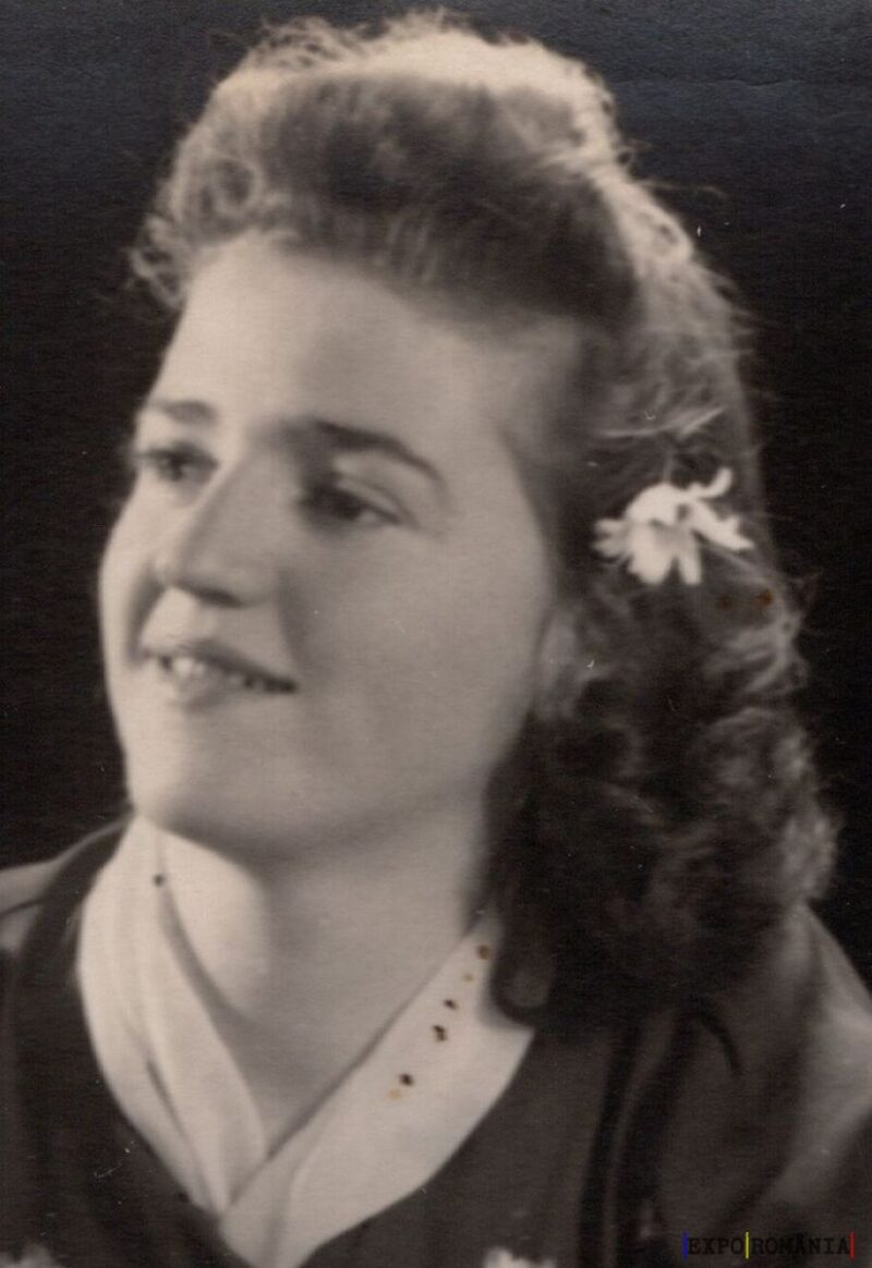 Portret alb-negru cu zâmbet și floare în păr